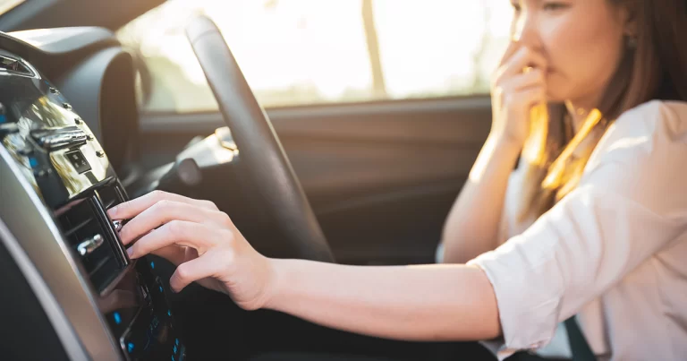 a female is driving a bad smelling car.