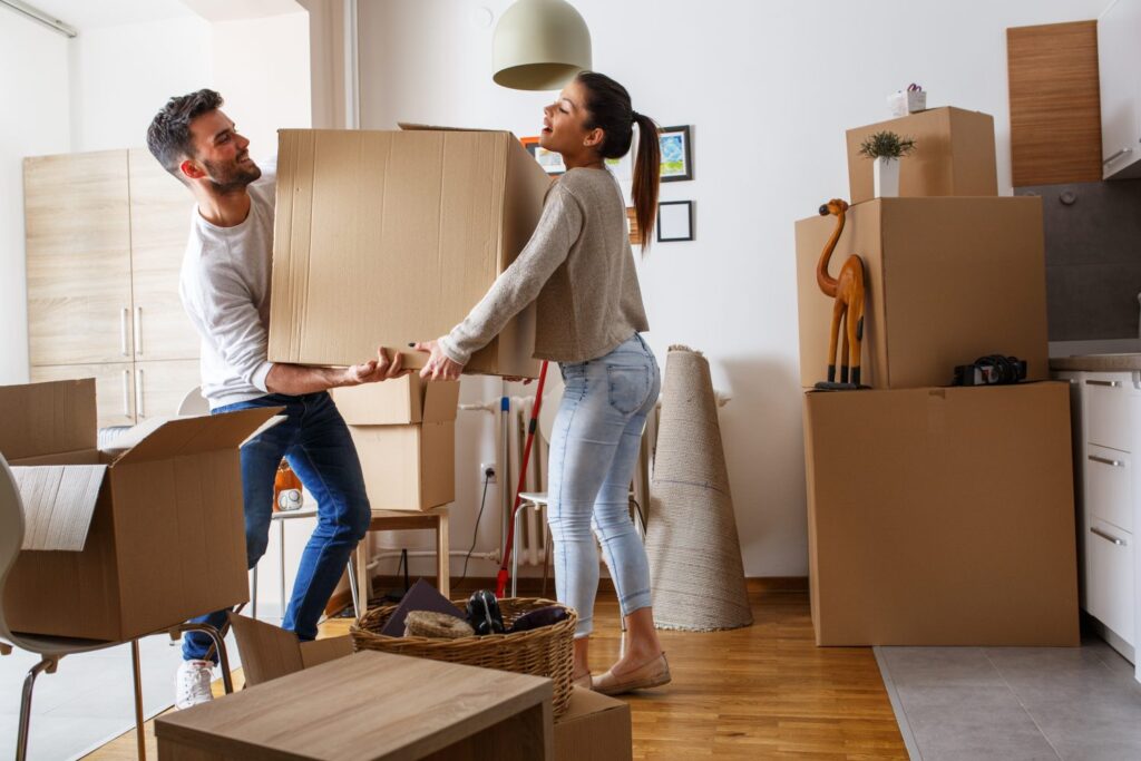 a couple holding a box seems like they are shifting to new apartment